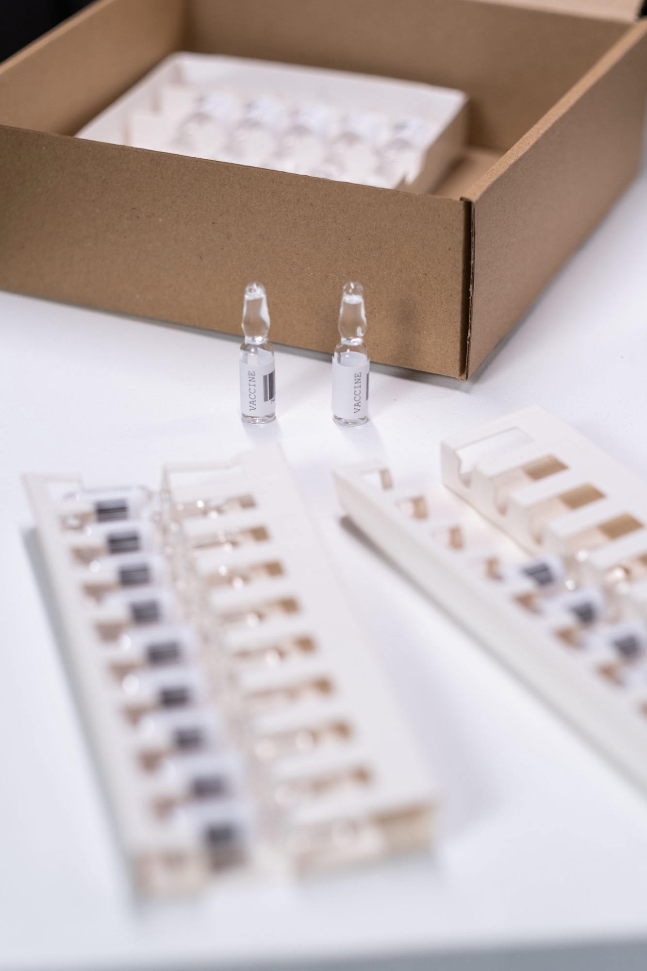 Sealed vials laid out beside a shipping carton